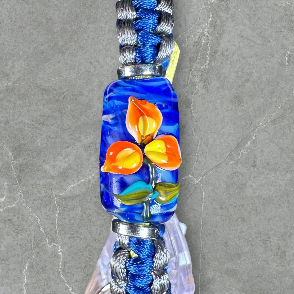Orange & yellow flower on blue, gray & yellow cord