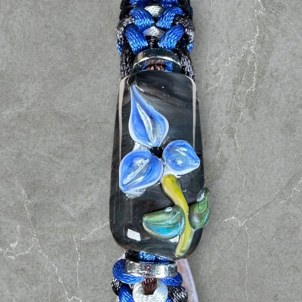 Blue flower on blue, white, & black cord
