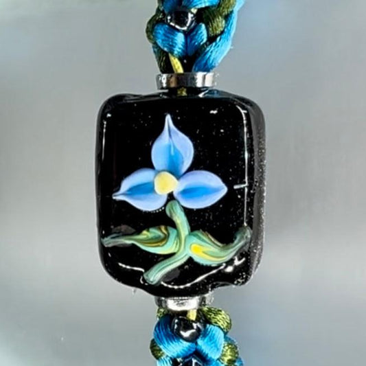 Blue flower on sky blue and green cord with deep blue seed beads