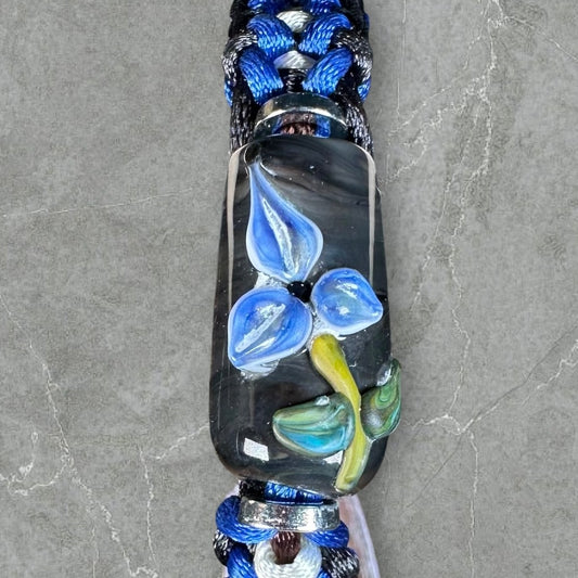 Blue flower on blue, white, & black cord